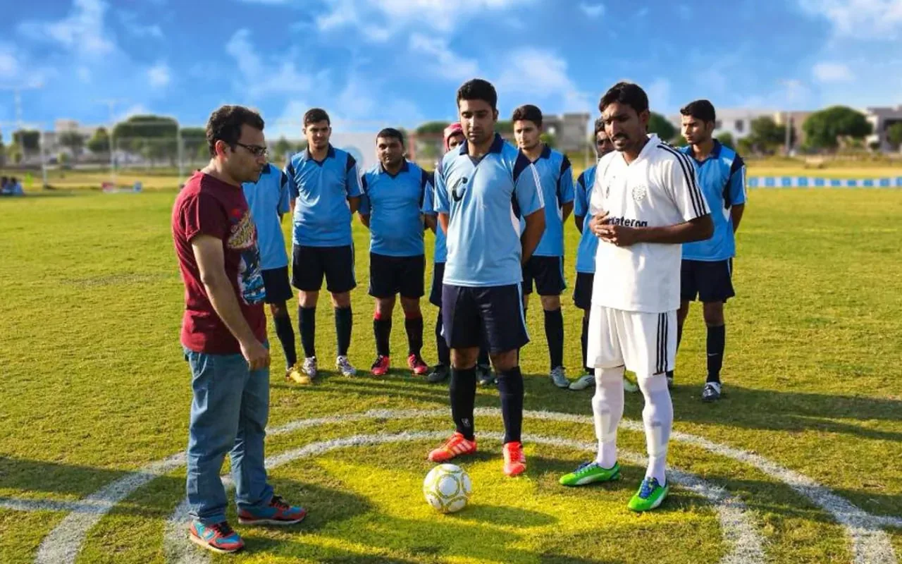 Players gathered around the ball at an early Feetball trial match